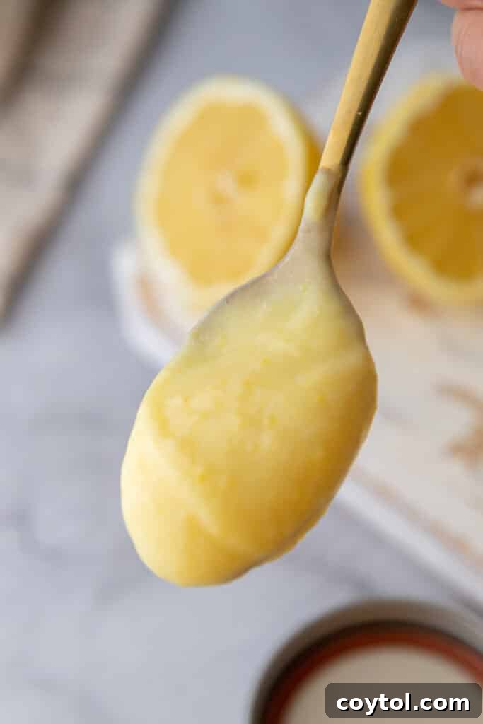 Microwave Lemon Curd: Zesty Perfection in Minutes 4 A spoonful of creamy, bright yellow microwave lemon curd.