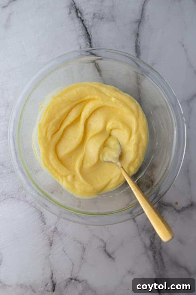 Microwave Lemon Curd: Zesty Perfection in Minutes 10 A spoon stirring a jar of chilled microwave lemon curd, showing its perfect consistency.