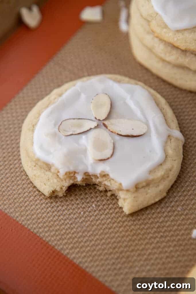A soft almond sugar cookie with a bite taken out, revealing its tender interior