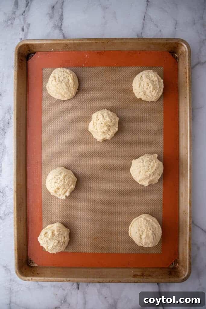 Scooped cookie dough portions on a parchment-lined baking sheet