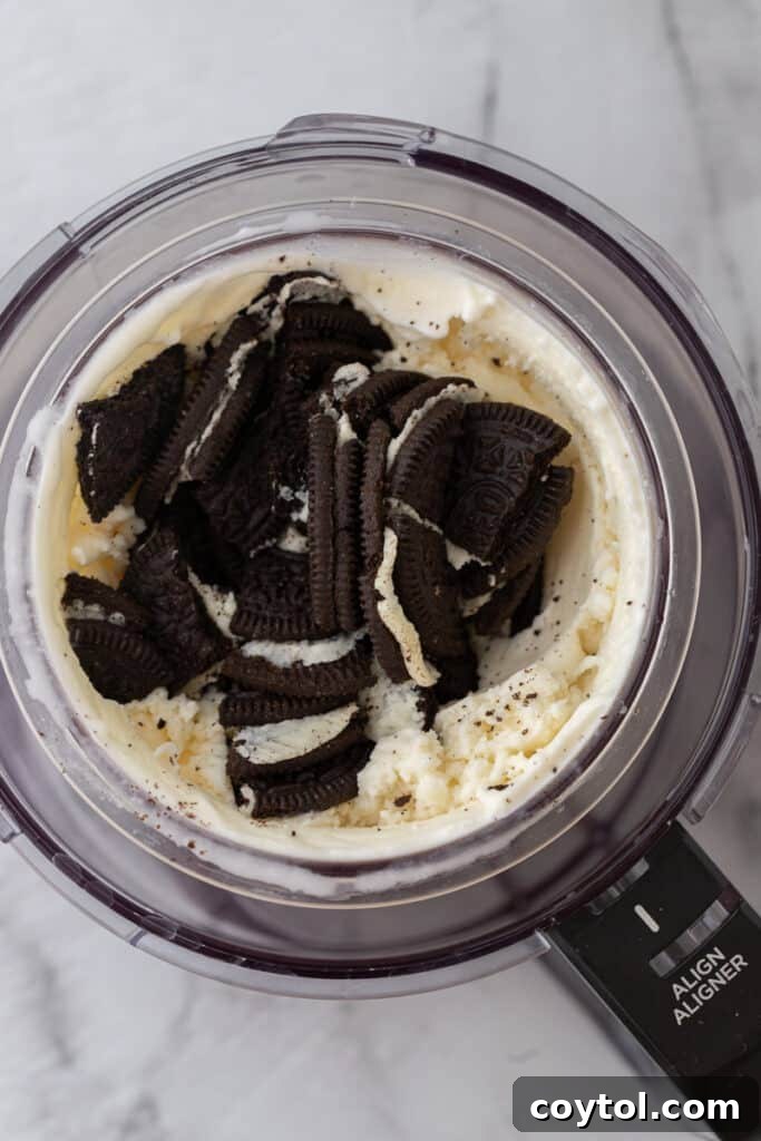 Ultimate Ninja Creami Cookies and Cream Perfection 9 oreo cookies added to the blended ingredients in a cup