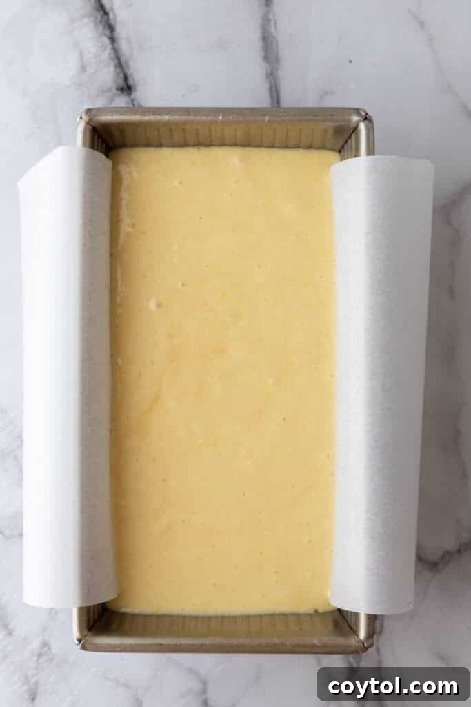 Cake batter poured into a parchment-lined loaf pan
