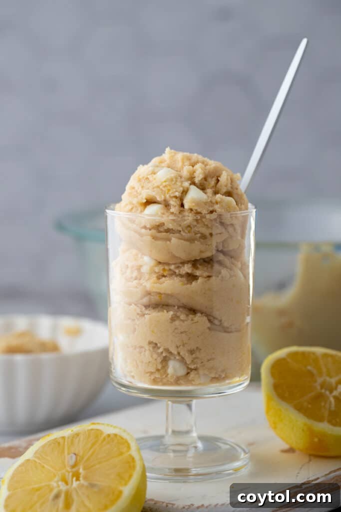 Side view of edible lemon cookie dough in a bowl, showing its texture and golden color