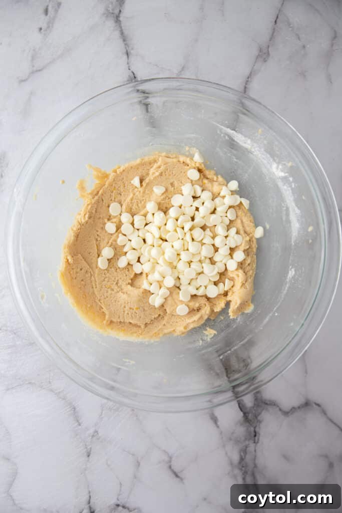 Lemon cookie dough with white chocolate chips folded in, showing even distribution