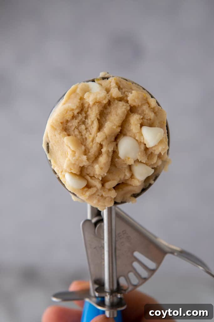 A scoop of edible lemon cookie dough, demonstrating its soft and pliable consistency