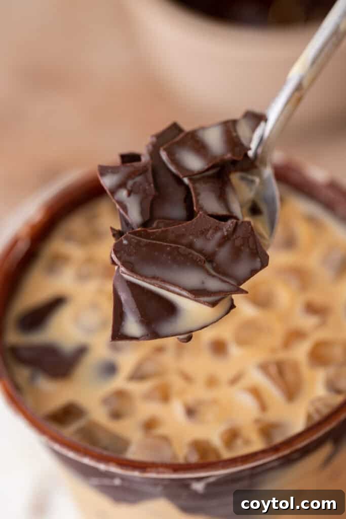 Recreate the Viral TikTok Cracking Iced Latte 9 Spoon holding shreds of cracked chocolate