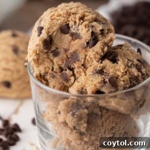 Irresistible Edible Chocolate Chip Cookie Dough 13 A scoop of rich, brown butter edible chocolate chip cookie dough presented appealingly in a small glass cup.