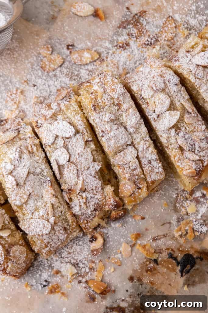 Overhead view of a perfectly baked Braided Almond Croissant Danish, lightly dusted with powdered sugar.