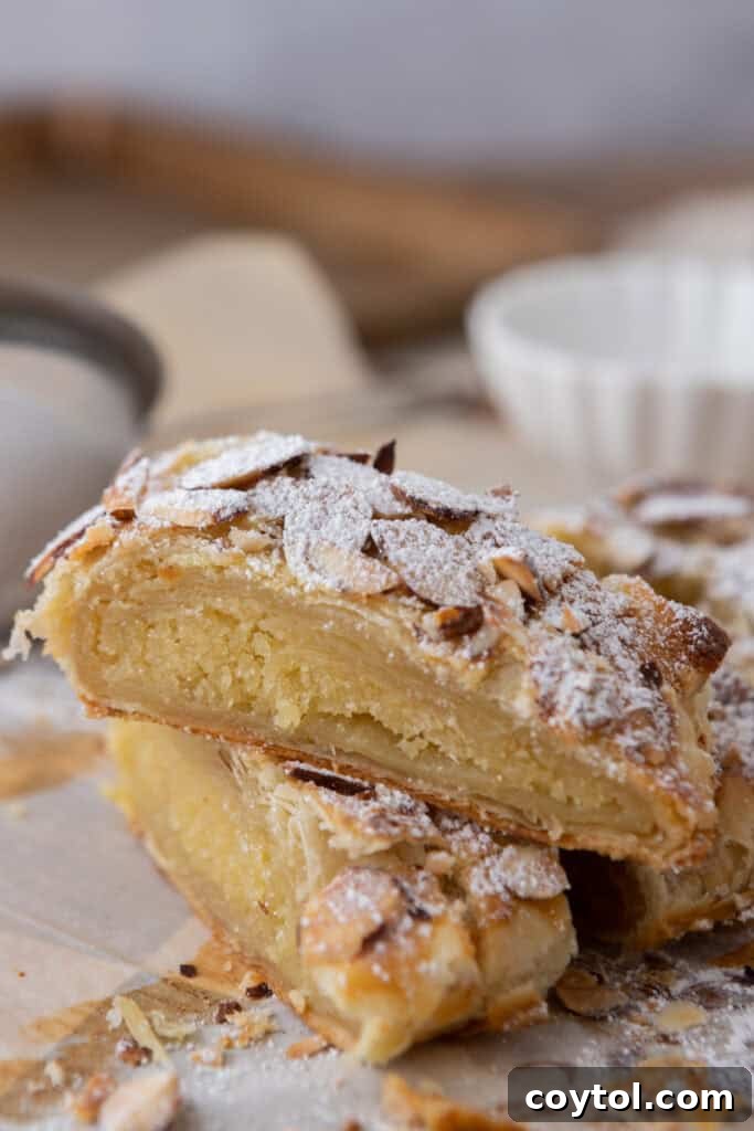 Two pieces of Braided Almond Croissant Danish stacked on a plate, showing the flaky layers and almond filling.