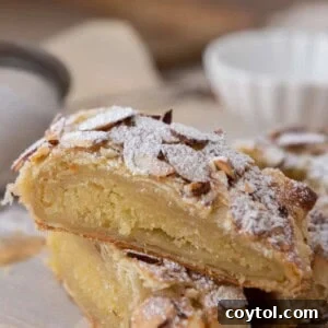 Two golden-brown pieces of Braided Almond Croissant Danish stacked on a plate.