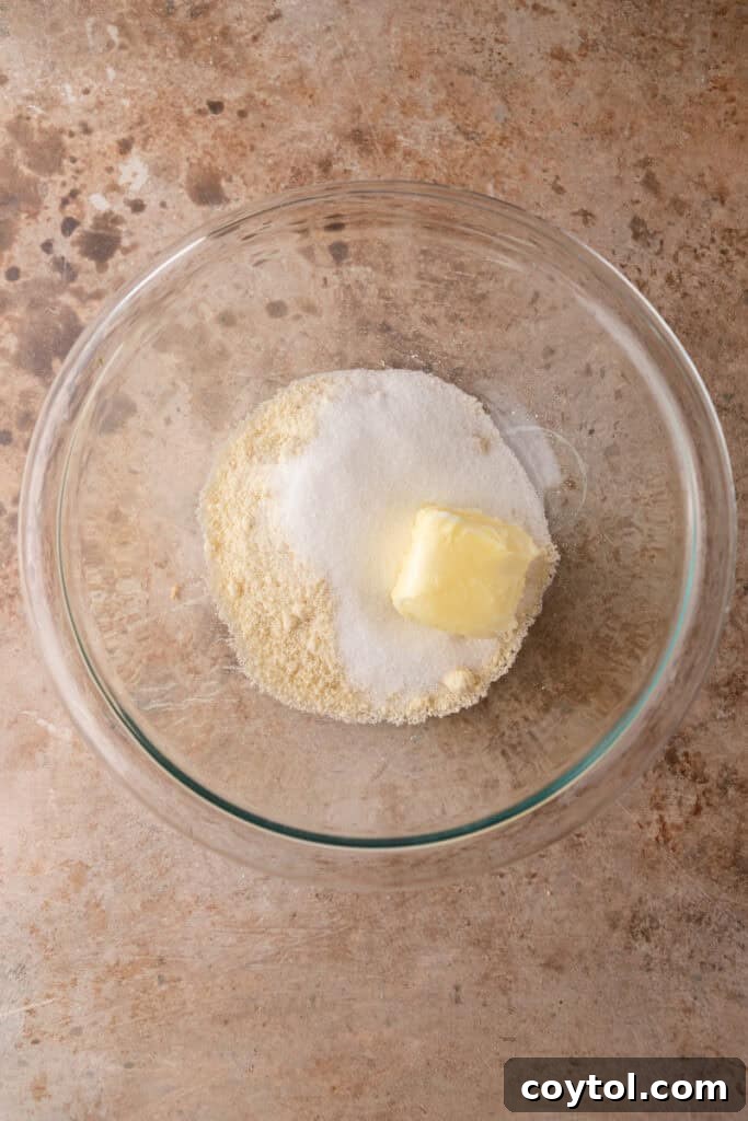 Softened butter added to frangipane ingredients in a bowl