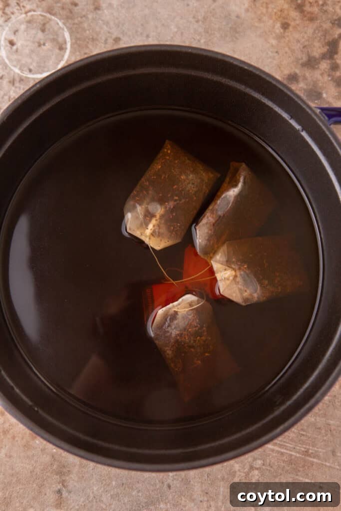 Black tea bags steeping in a pot of hot water