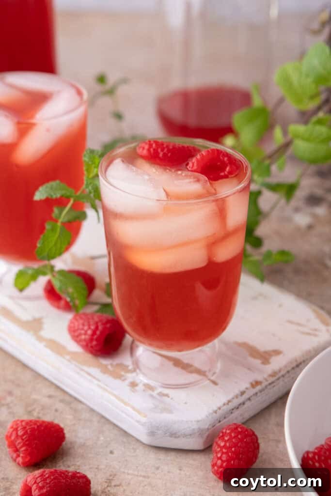 Side shot of the raspberry iced tea recipe in a glass with ice