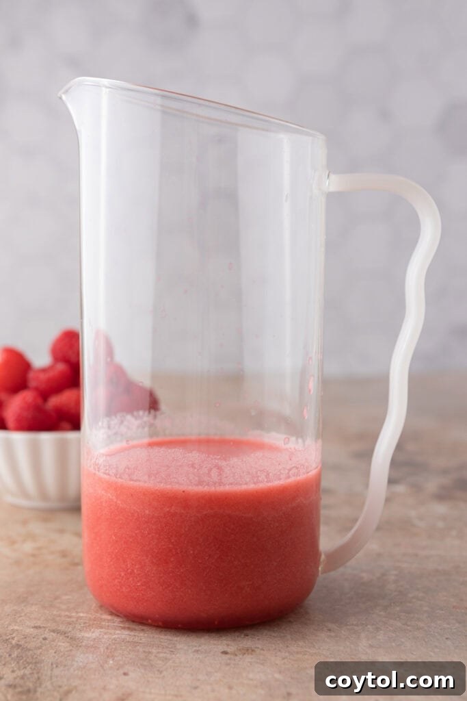 Partially filled pitcher with raspberry syrup
