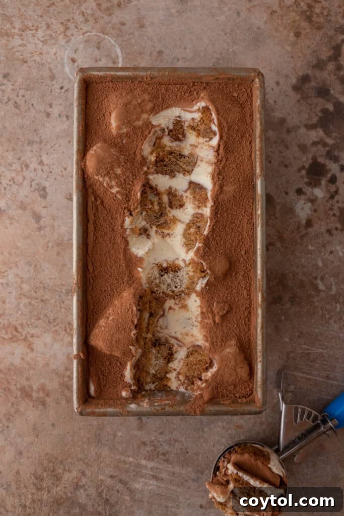 Fully frozen no-churn tiramisu ice cream in a loaf pan, ready to be scooped.