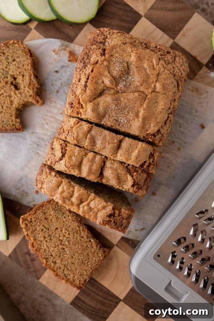 Overhead view of a baked zucchini bread loaf on a wooden cutting board.