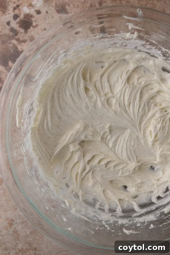 Cream cheese frosting ingredients thoroughly mixed in a bowl, showing a smooth and creamy texture.