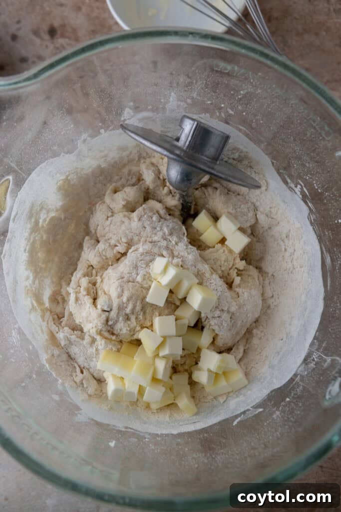 Dry and wet ingredients for cinnamon roll dough partially mixed in a bowl, before full incorporation.