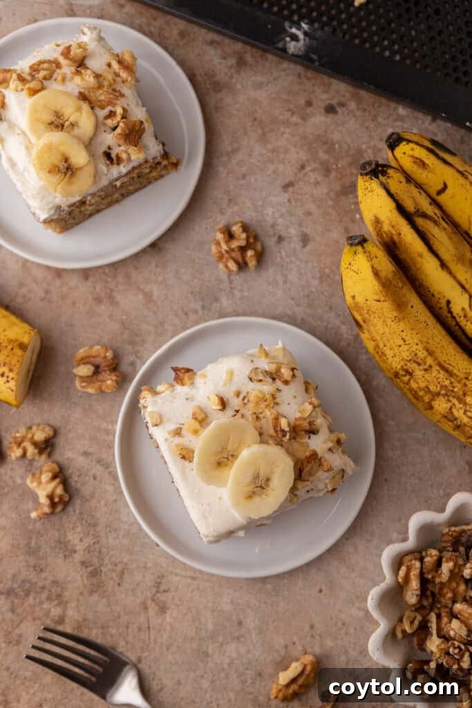 An overhead view of several slices of banana cake with cream cheese frosting arranged on plates, ready to be served.