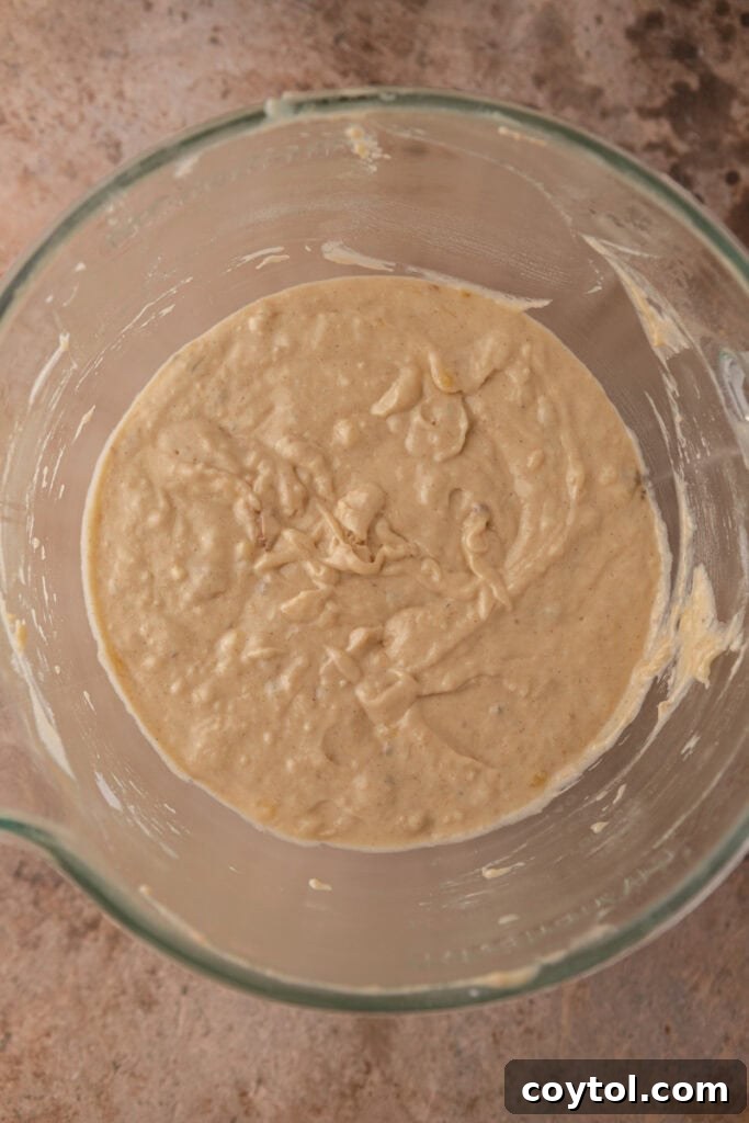 Cake batter with wet and dry ingredients just combined, showing a smooth, thick consistency.