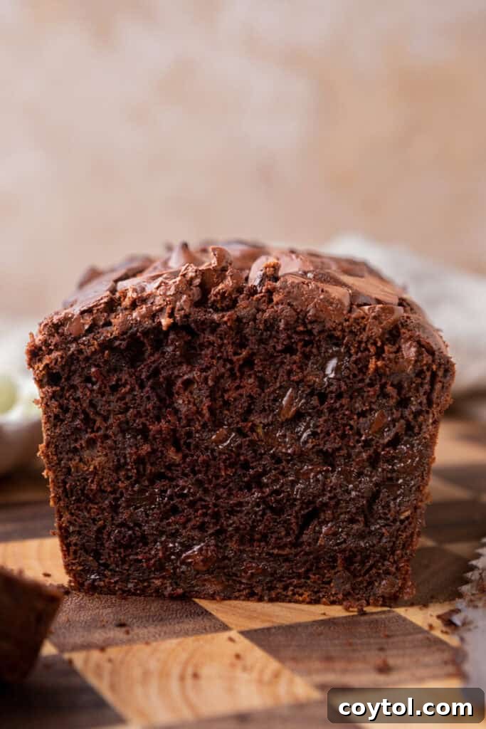 Side shot of a fully baked Double Chocolate Zucchini Bread loaf on a cooling rack, showcasing its beautiful texture.