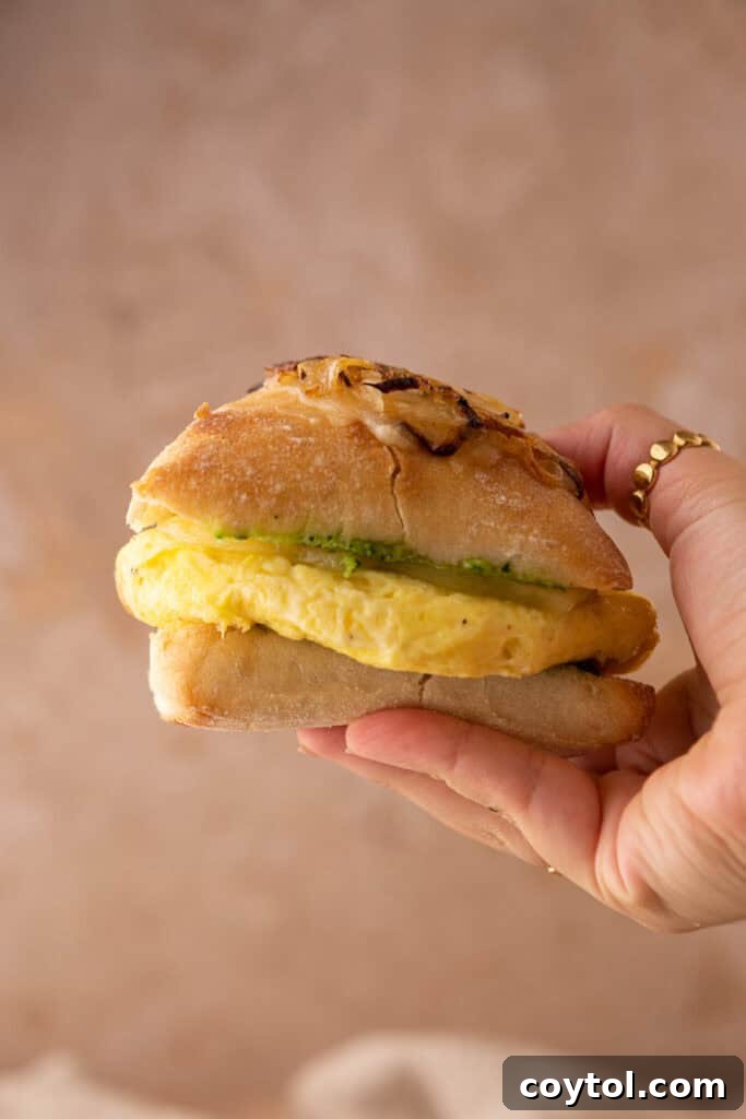 Elevate Your Breakfast Starbucks Style Egg Kale Pesto Mozzarella Sandwich 11 Starbucks egg kale pesto mozzarella sandwich recipe being held up by a hand