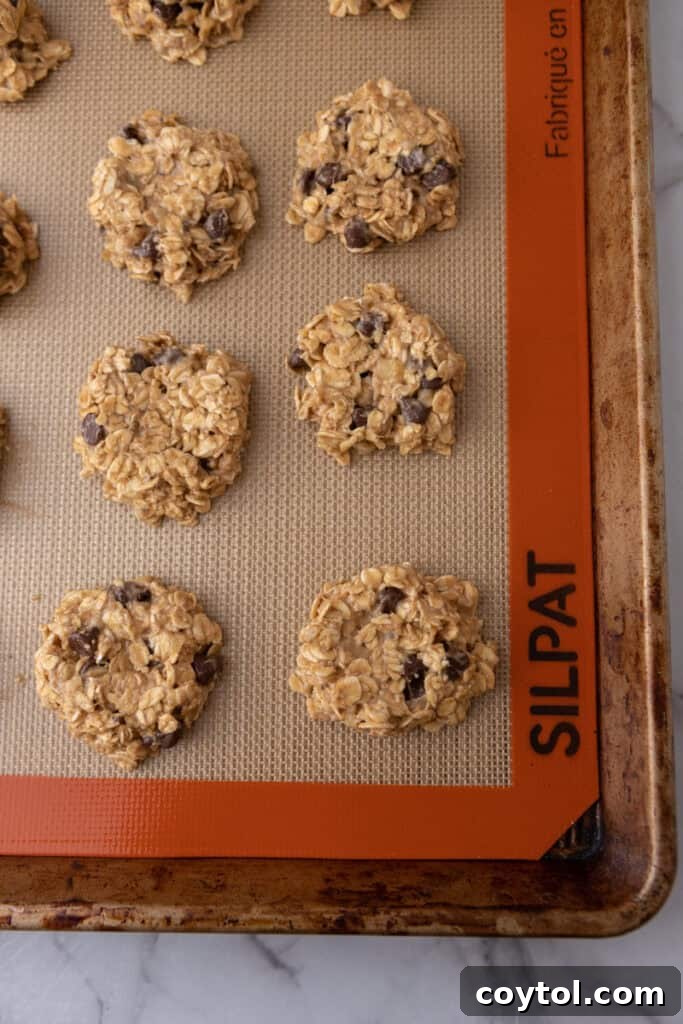 flattened balls of dough on a baking sheet