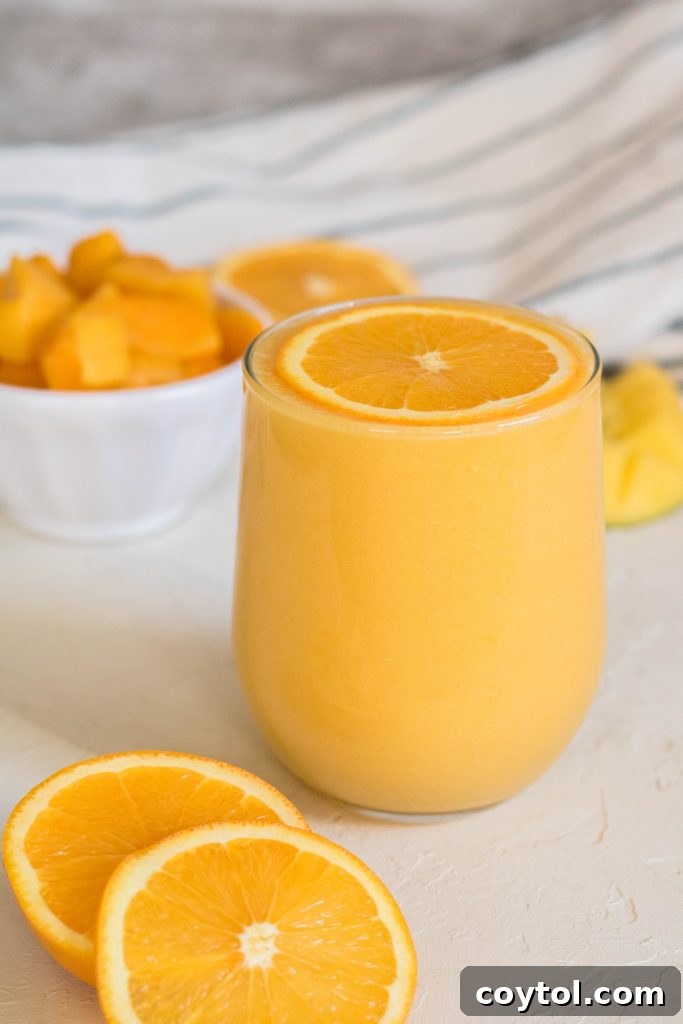 Mango orange smoothie with an orange slice on top