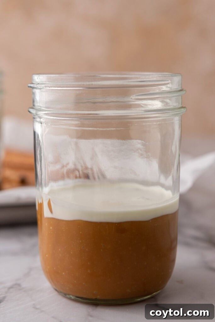 Melted caramels and heavy cream in a cup, ready for dipping pretzel rods.