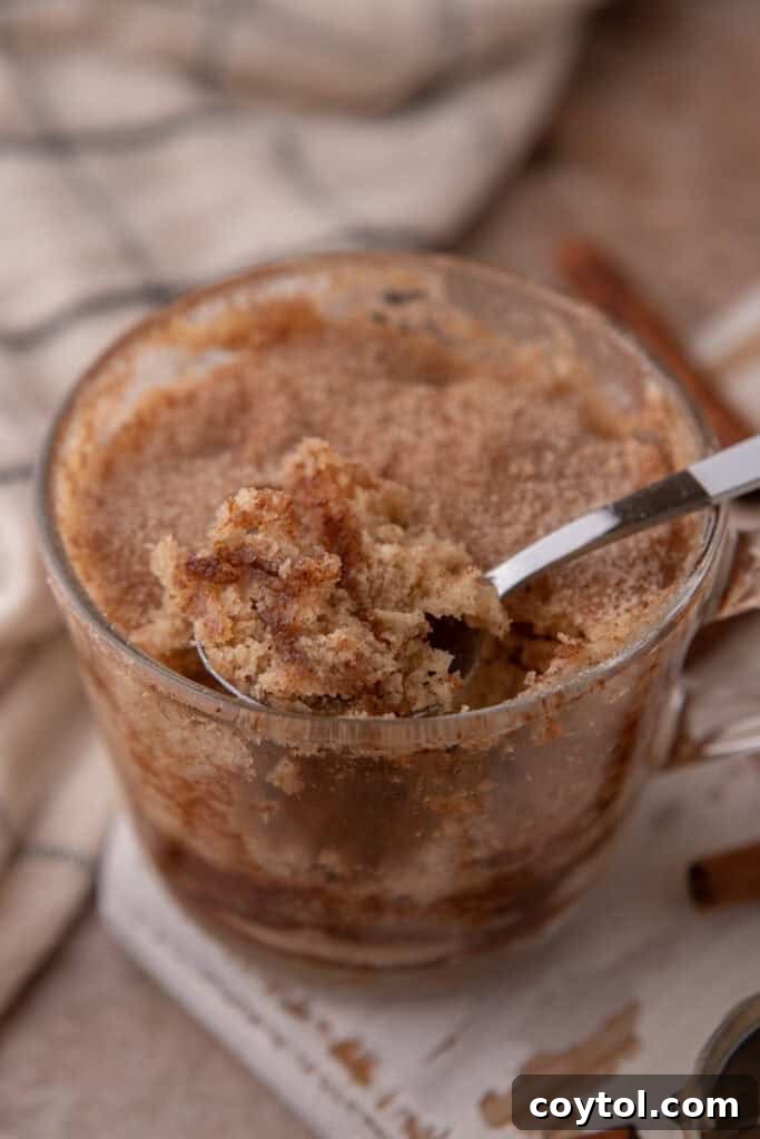 snickerdoodle mug cake recipe in a cup getting scooped