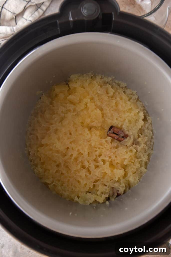 Steaming, cooked apples soft and tender inside the Instant Pot after pressure release, ready for mashing into applesauce.