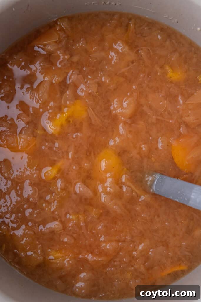 Cooked apples and orange in an Instant Pot after pressure cooking, softened and ready for mashing.
