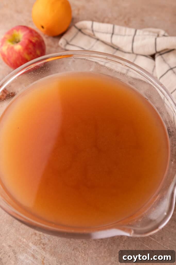 A large bowl filled with freshly strained homemade Instant Pot apple cider, ready to be served.