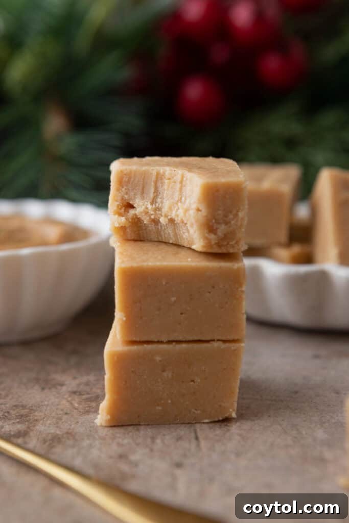 Instant Microwave Peanut Butter Fudge 4 Stacked pieces of creamy microwave peanut butter fudge, showcasing its delicious texture.