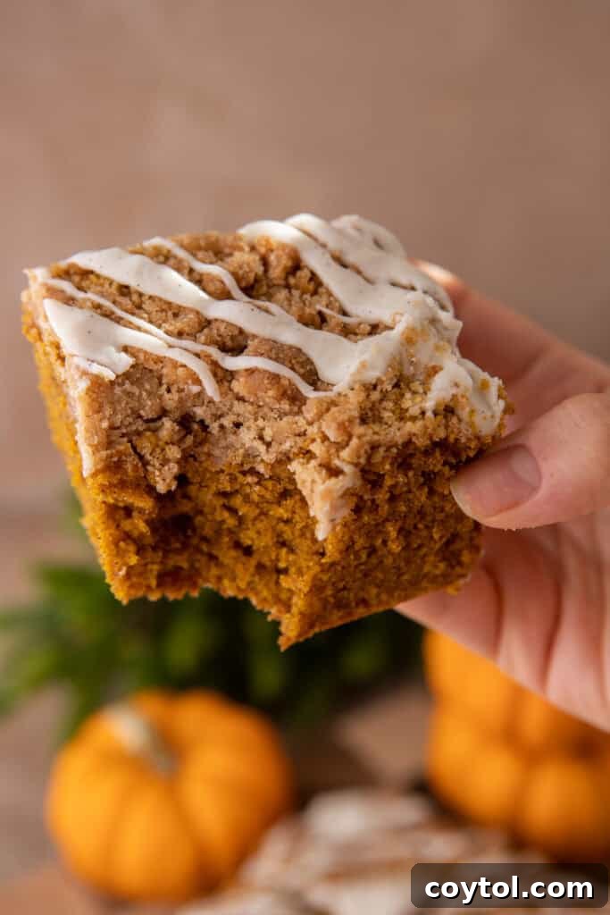 pumpkin coffee cake recipe being held up by a hand