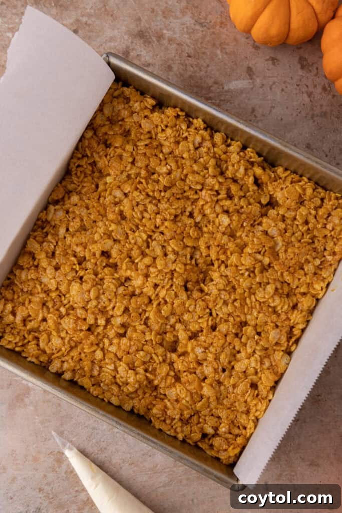 Autumn Pumpkin Rice Krispie Perfection 9 Pumpkin Rice Krispie treat mixture pressed evenly into a square pan.
