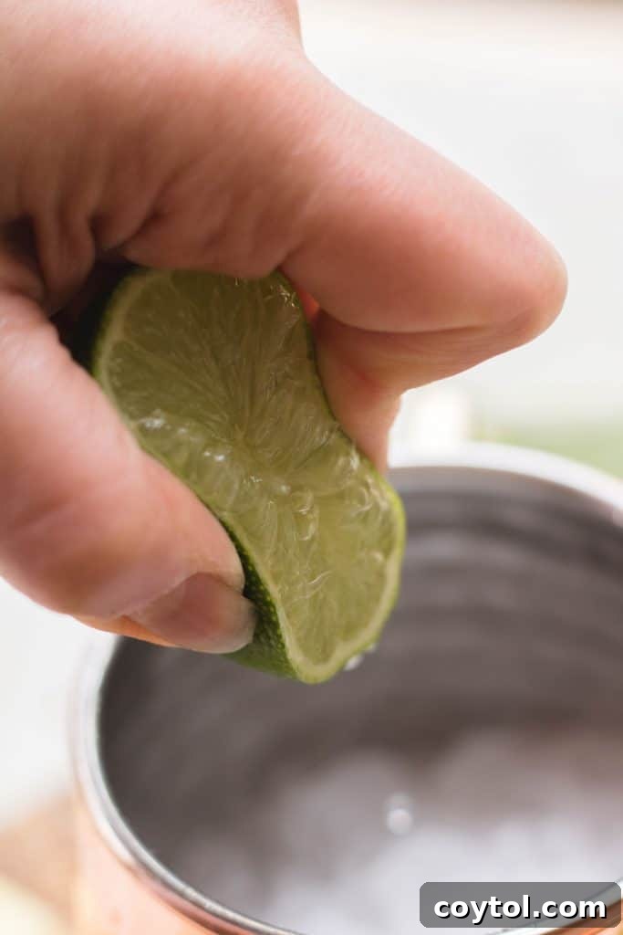 Adding crushed ice to a copper Moscow Mule mug