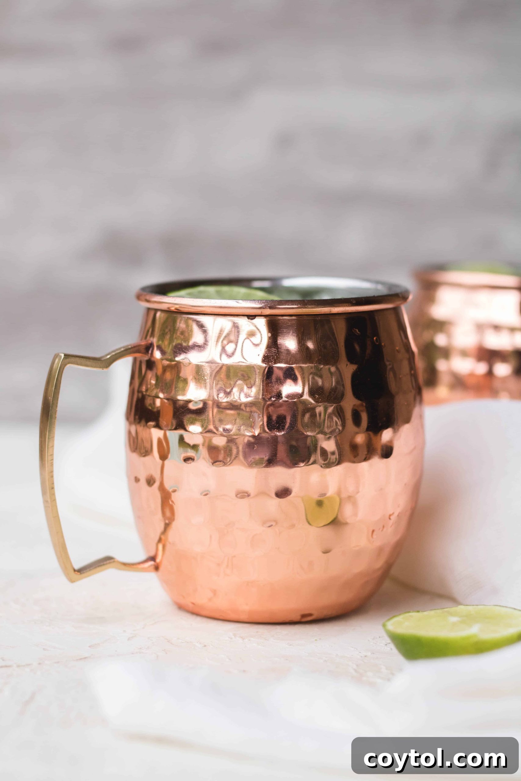 Hand holding a copper mug filled with Virgin Matcha Moscow Mule, ready to drink
