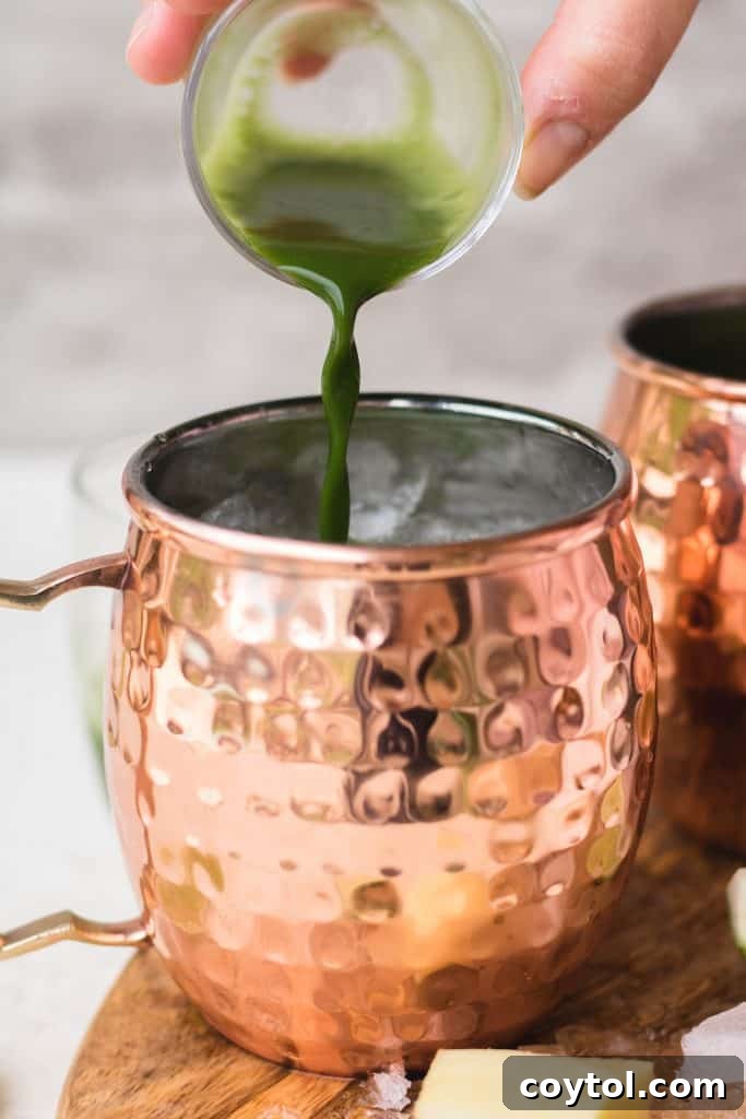 Pouring whisked matcha into a Moscow Mule mug