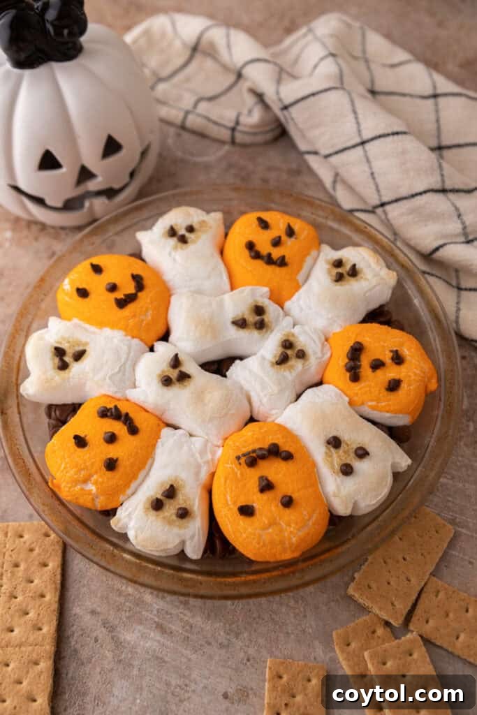 Wicked Good Halloween Smores Dip 9 chocolate chips in a baking dish with marshmallows on top fully baked, ready to serve