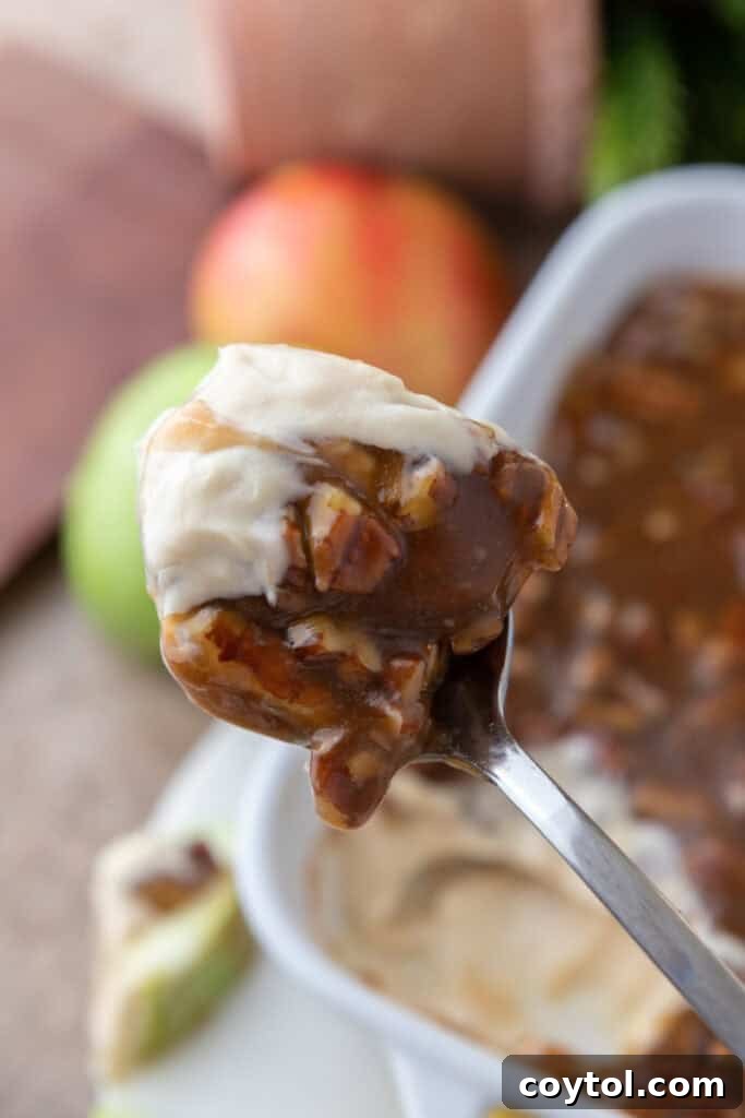 A spoonful of delicious pecan pie dip, showcasing the creamy base and the rich pecan topping.