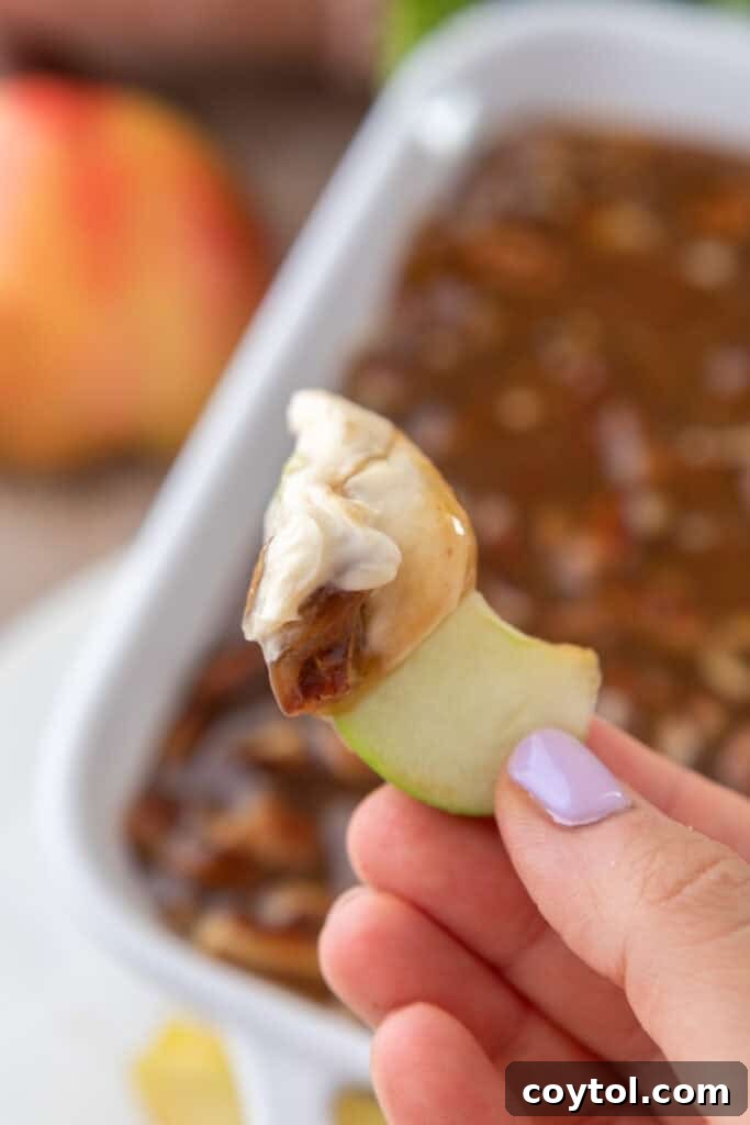 A slice of apple generously coated with pecan pie dip.