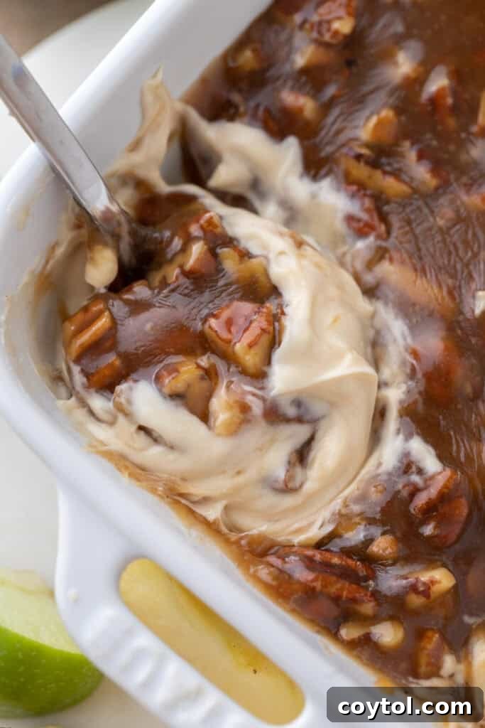 A scoop being taken from the freshly made pecan pie dip, showing off its layered texture.