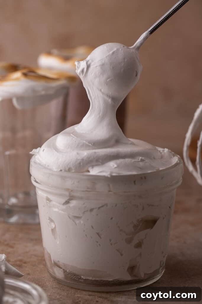 homemade marshmallow fluff recipe being scooped out of a cup