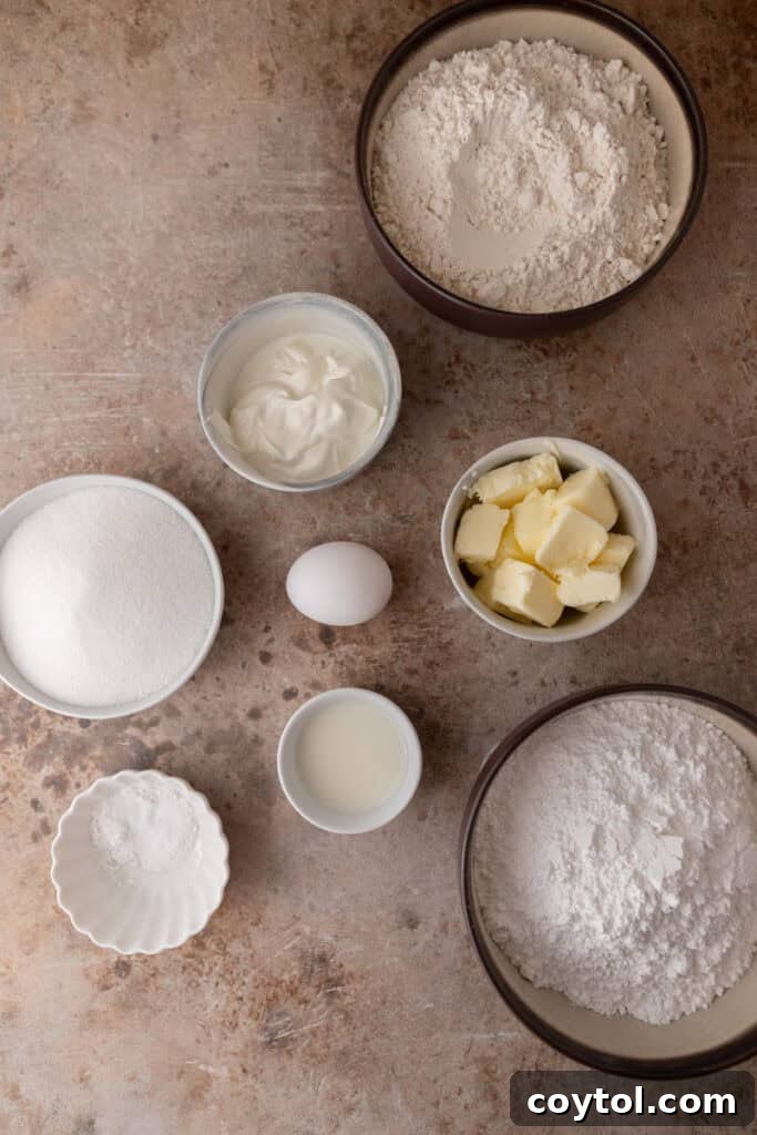 Pillowy Old-Fashioned Sour Cream Sugar Cookies 3 Ingredients for sour cream sugar cookies arranged on a table, including flour, sugar, butter, sour cream, egg, and milk.