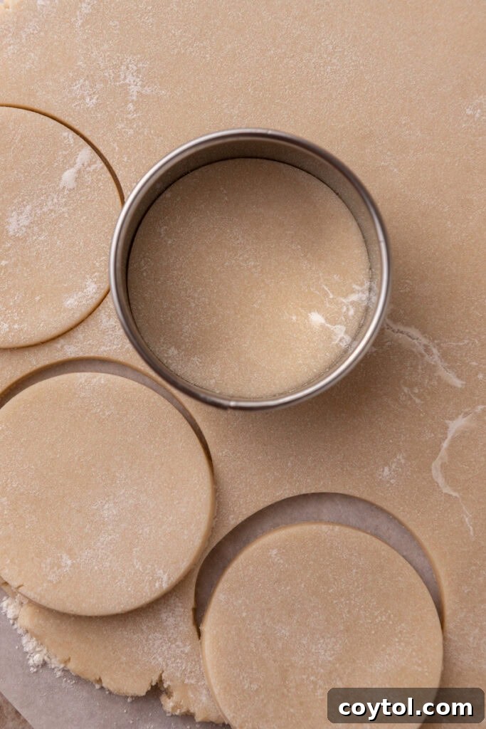 Pillowy Old-Fashioned Sour Cream Sugar Cookies 9 Rolled-out sour cream sugar cookie dough with round cookie cutter pressing out circles.