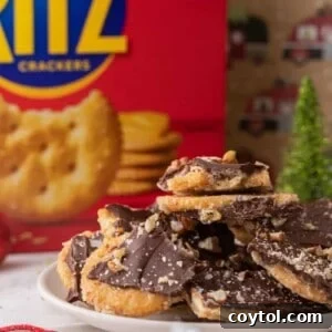 Stack of homemade Ritz cracker Christmas crack topped with pecans and flaky salt.