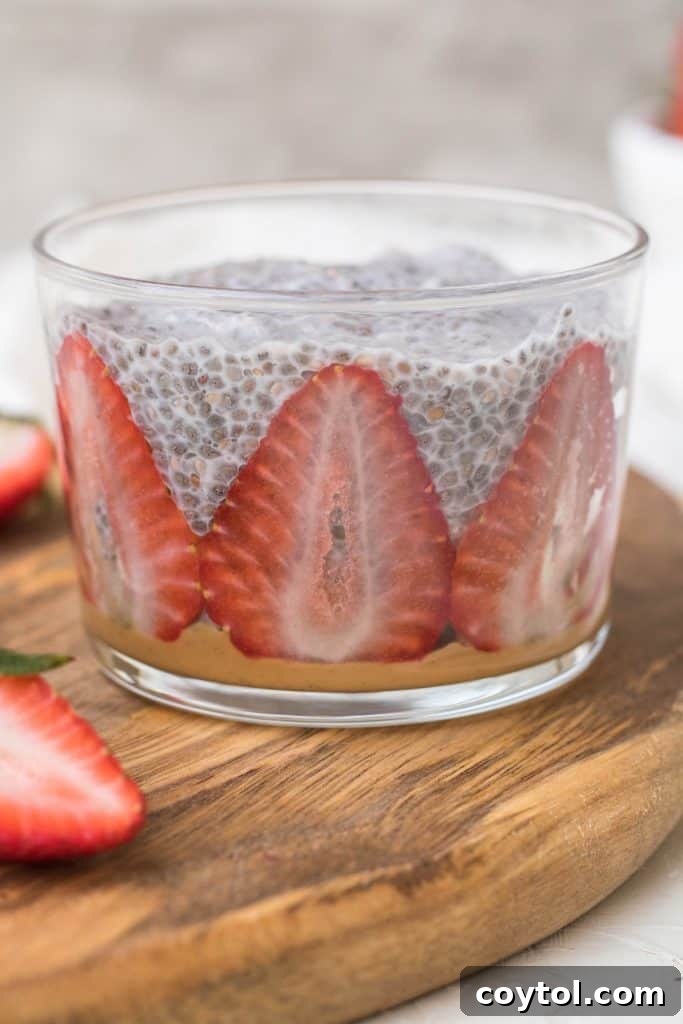 Strawberry Peanut Butter Chia Dream 18 Chia seed pudding being spooned into a serving cup over peanut butter.