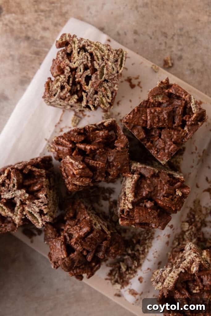 Set chocolate cereal squares on parchment paper, ready for slicing.