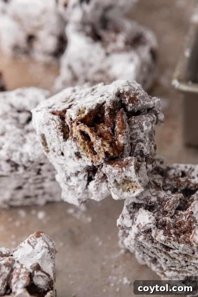 Muddy Buddy Bars stacked neatly, showing off their generous powdered sugar coating.